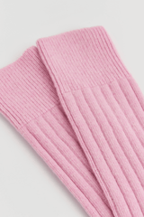 Pink merino bed socks in a soft ribbed design, perfect for warmth and comfort.