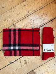 Red plaid scarf and socks on a wooden surface